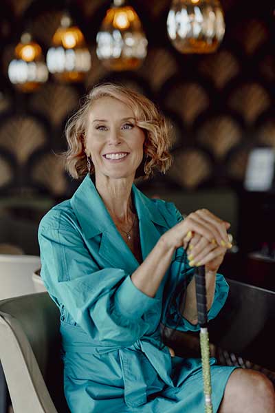 Joanne posing with her cane dressed to kill