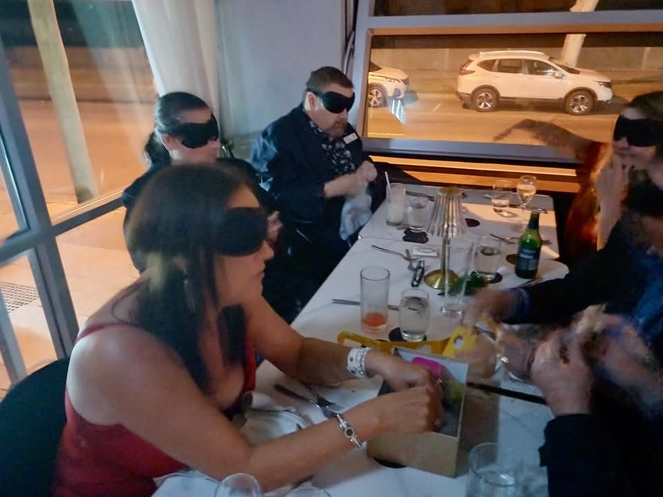blindfolded dinner party seated at a table